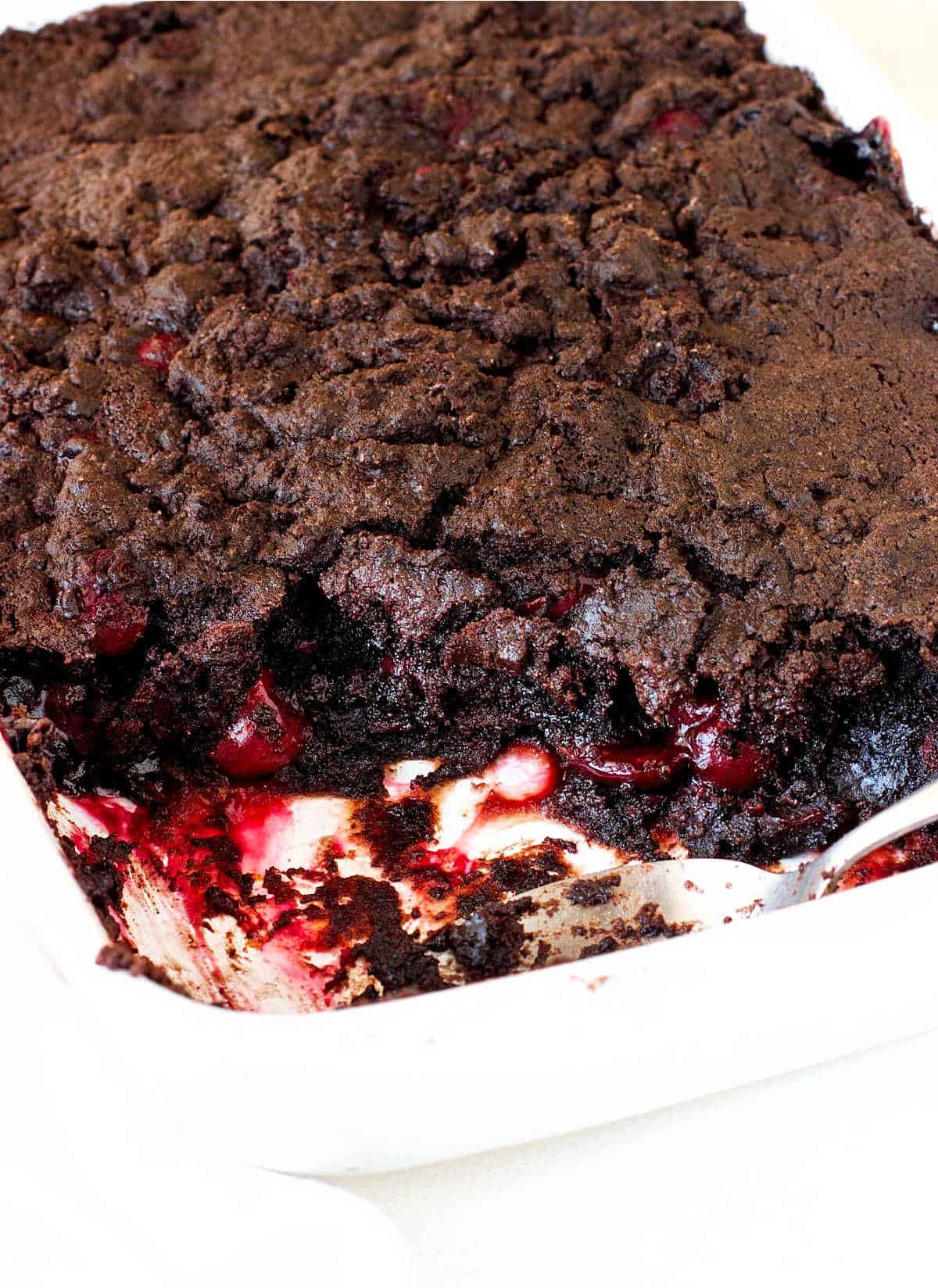 Chocolate cherry dump cake in a rectangular white ceramic dish.